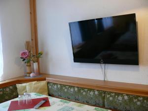 大舍瑙Zur deutschen Eiche的挂在沙发上方墙上的平面电视