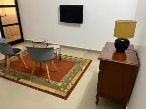 达喀尔Residence B&B Hibiscus的客厅配有桌子、两把椅子和一盏灯