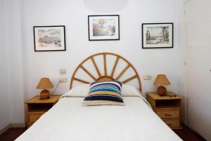 托里代巴拉AT070 Platja的卧室配有一张床,墙上有三幅照片