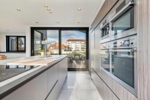科克赛德Villa Paradis - De ultieme kustvilla met zwembad !的一间厨房,配有白色的橱柜和大窗户