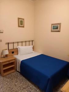 斯库索港唐佩德罗酒店的一间卧室配有蓝色的床和床头柜