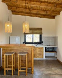 卡法亚特Complejo Los Olivos - casa 3 y 4的厨房配有带凳子的大型木制台面