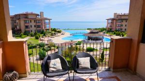 托波拉Apartment DECORA Sea View的阳台配有两把椅子,享有游泳池的景色