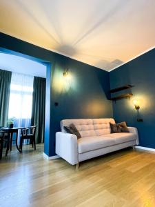 卡尔帕奇Perła Sudetów by Stay inn Hotels的客厅配有蓝色墙壁上的白色沙发