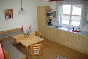 滨湖新锡德尔Haus Königshofer的厨房配有桌子和桌子,设有用餐室。