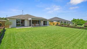 陶朗加The Lakehouse - Tauranga Holiday Home的前面有大草坪的房子