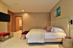 滨海萨纳里法兰多乐酒店的一间卧室配有一张大床和一台平面电视