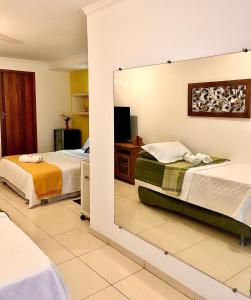 帕拉蒂Cantinho da Bruxa的酒店客房,设有两张床和镜子