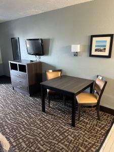 布兰登Brandon Motor Lodge的酒店客房配有桌椅和电视。