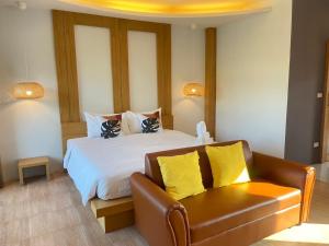 穆克莱克Wangpruksa Resort的一间卧室配有一张床和一张皮沙发