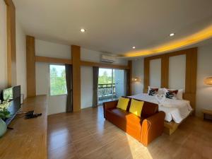 穆克莱克Wangpruksa Resort的一间大卧室,配有一张床和一张沙发