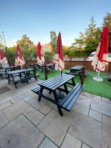 巴纳德城堡The Redwell Inn的一组野餐桌,在草坪上摆放着雨伞