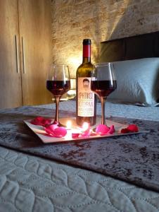 拉夫里翁Harmony的床上的一瓶葡萄酒和两杯酒杯