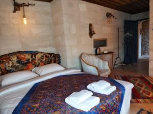 内夫谢希尔Duru Cappadocia Stone House的一间卧室配有带毛巾的床
