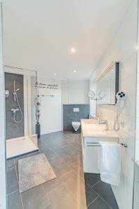 埃特尔布吕克赫克曼酒店的一间带两个盥洗盆、淋浴和卫生间的浴室