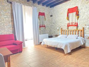 坎塔维耶哈Casa Sara的一间卧室配有一张床和一张红色的沙发