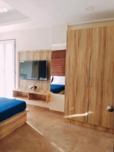 巴加C V Inn的一间卧室配有木制橱柜和一台平面电视。
