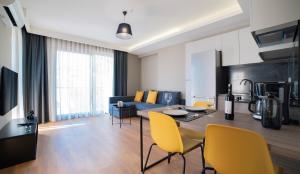安塔利亚VESTA SUITES的客厅配有桌子和黄色椅子