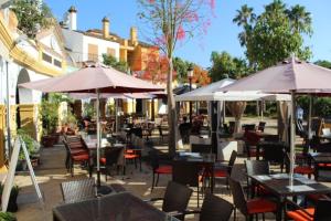 圣罗克Nueva Alcaidesa 2104 - Sea Sun and Green的室外餐厅设有桌椅和遮阳伞。