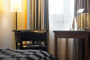 维也纳维也纳市假日酒店的卧室配有书桌和靠窗的椅子
