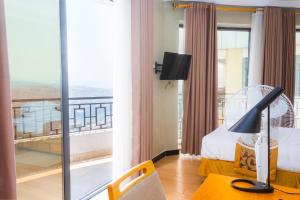 基加利Tropical Plaza Apartments的酒店客房设有一张床和一个阳台。