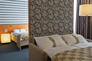 维也纳维也纳市假日酒店的酒店客房,设有一张床铺和一面墙纸