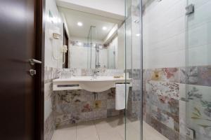 百乐·奥拉内斯蒂Hotel Olanesti & Spa Medical的一间带水槽和玻璃淋浴的浴室