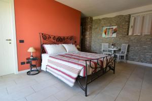 Albaretto Della Torre 拉罗拉旅馆的一间卧室配有一张橙色墙壁的床