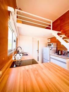 何塞伊格纳西奥Tiny House Aire en La Juanita的一间铺有木地板的厨房和楼梯