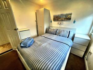 桑当Wight Waves Holidays的一间小卧室,配有一张带条纹床垫的床