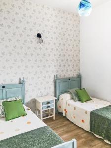 丰卡连特德拉帕尔马Casa Las Enanitas I - Casa Leo的两张床位于带绿色和白色墙壁的客房