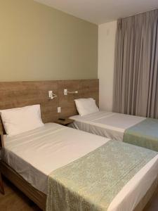 维多利亚普拉亚都坎托司丽普酒店的配有两张床的酒店客房中的两张床