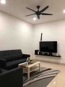 雪邦MOFA Homestay Near KLIA Airport的客厅配有黑色沙发和平面电视。