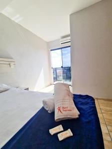 塔瓜汀加Hotel Supreme - Pistão Sul - Próximo ao Taguatinga Shopping的一间卧室配有一张床,上面有两条毛巾