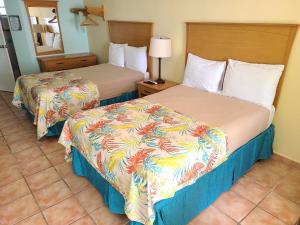 毛纳沃帕拉多马纳卡瑞比-马纳博的酒店客房,设有两张床和镜子