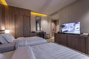 利雅德Land walk Hotel的酒店客房设有两张床和一台平面电视。