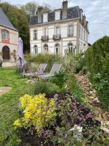 Monthureux-le-SecLE CHATEAU DE MONTHUREUX LE SEC的花卉花园内带两把椅子的房子