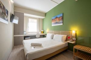 都灵格兰莫格尔最佳品质酒店的一间卧室设有一张大床和绿色的墙壁