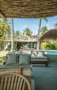 佩德拉斯港Zai Patacho的一个带长沙发和棕榈树的庭院和一个度假村