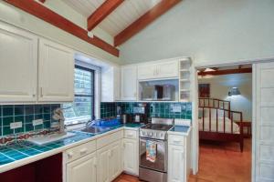 丹格里加Condo #27 @ Beachside Villas的厨房配有白色橱柜和炉灶烤箱。
