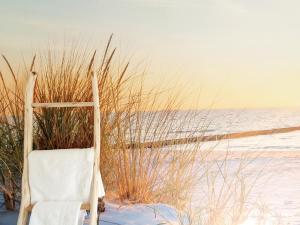 赫拉尔兹贝亨Vakantiewoning De Gavers的海滩旁的雪地里摆放着一张白色的椅子