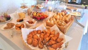 博尔马斯·莱斯·米默萨斯Hotel Les Jardins de Bormes的自助餐,包括桌上的糕点篮