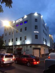 瓜达拉哈拉Hotel Vigo的门前有车辆停放的酒店