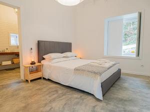 蓬德利马Casa Som do Rio的白色的卧室设有一张大床和一个窗户