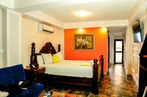 San FelipeHotel Mi Paraíso Río Dulce的一间卧室配有一张橙色墙壁的床