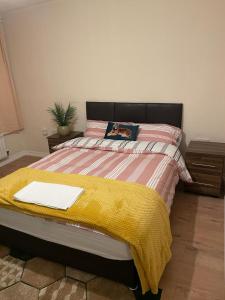 ThamesmeadLovely Shared 3 Bed Home Near The Thames的一间卧室配有一张黄色毯子床