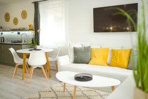 杰尔Raba92 Apartman House的客厅配有白色的沙发和桌子