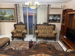 都拉斯LuxurySeaview Apartment的客厅配有两把椅子和电视