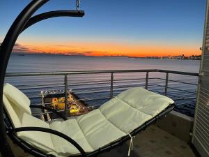 都拉斯LuxurySeaview Apartment的阳台上配有椅子,在船上享有日落美景