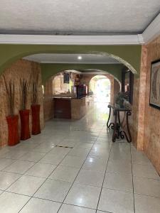 瓜达拉哈拉Hotel Vigo的走廊上设有拱门,厨房里设有桌子